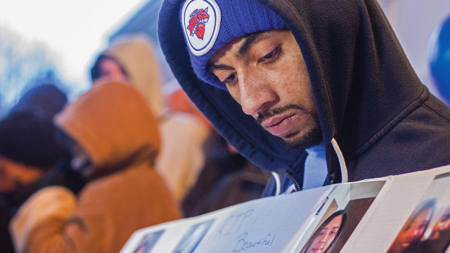 Nate Grant holds a poster board for community members, loved ones and friends of 36-year-old Letitia Davis to sign in remembrance at a vigil held Sunday evening at Fairmount Park. Davis was beaten, sexually assaulted and burned on Nov. 14 at Fairmount Park. She passed away from her injuries early Saturday. Donations to help cover her medical bills will be accepted at Credit Union of America locations in the Wichita area under the "Loving Mother" fund. (Photo by Kevin Brown)