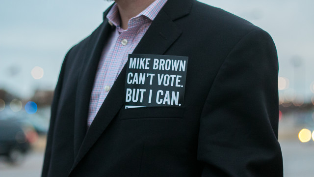 A protester carries a sticker in their pocket that says, “Mike Brown can’t vote. But I can.” at a community vigil held near WSU on Monday to highlight similarities with Wichita and Ferguson, Mo. (Kevin Brown/The Sunflower)