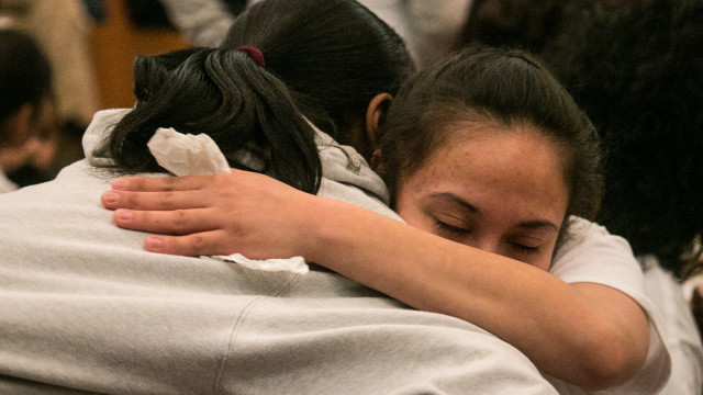 Family members of JP Quintero hug during a donation session at a vigil held on January 7, 2015 in lieu of his death. Quintero was fatally wounded in a police shooting on January 3. (Kevin Brown/The Wichita Eagle)